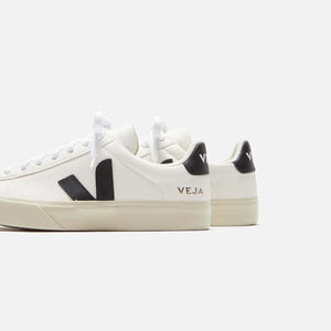 White and black sneakers in ChromeFree leather by Veja, featuring organic cotton laces and sustainable materials.